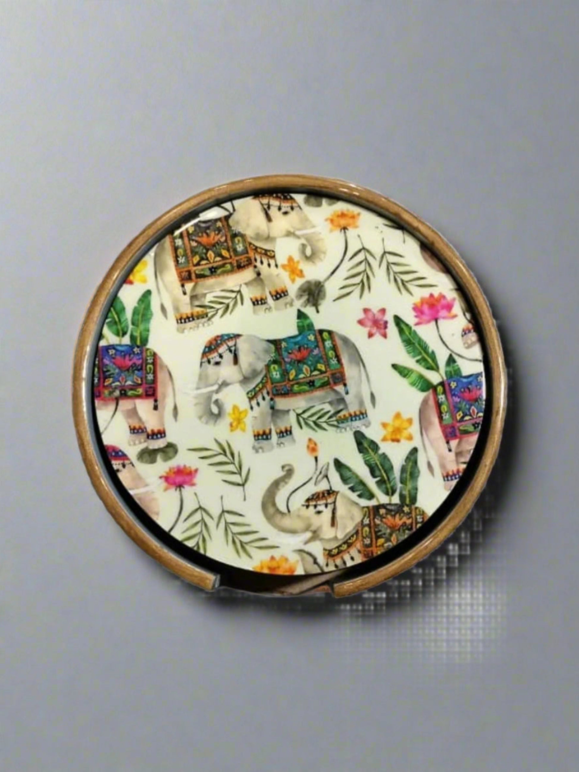 Round compact mirror with elephant and floral design on a gray background